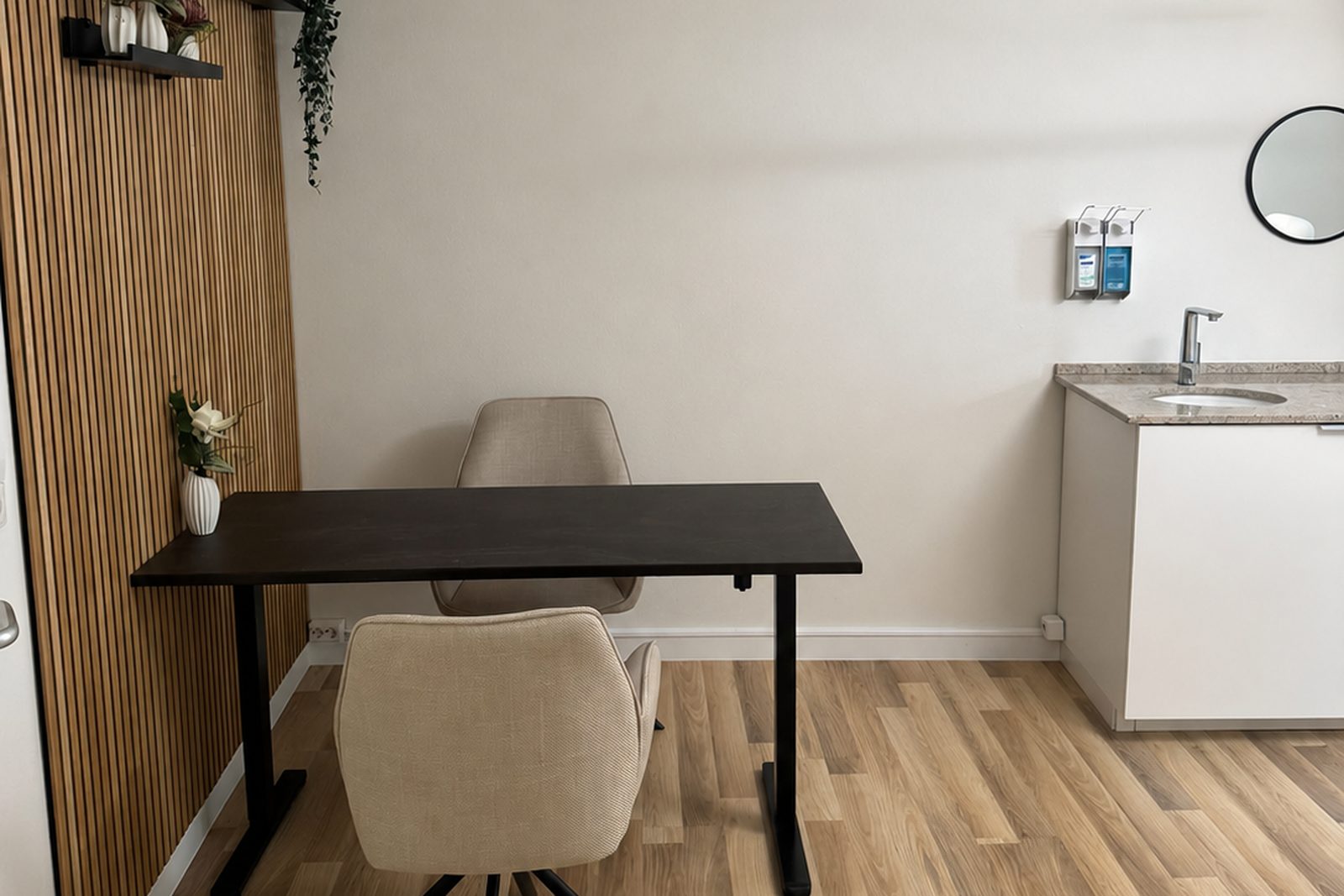 Talk room with desk, two chairs and a wood-slat wall